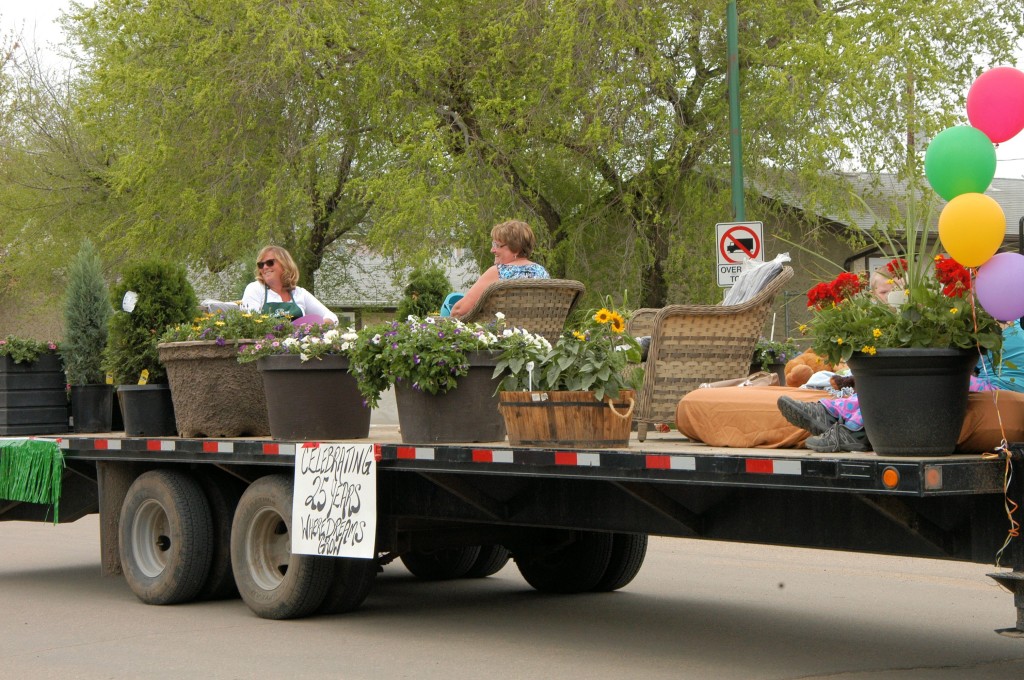 Kathy Paggett and Diane Eby smile at the people lining the route as they ride the K.P. Gardens float in the Unity, Saskatchewan annual Western Days parade, on Saturday, May 31, 2014.